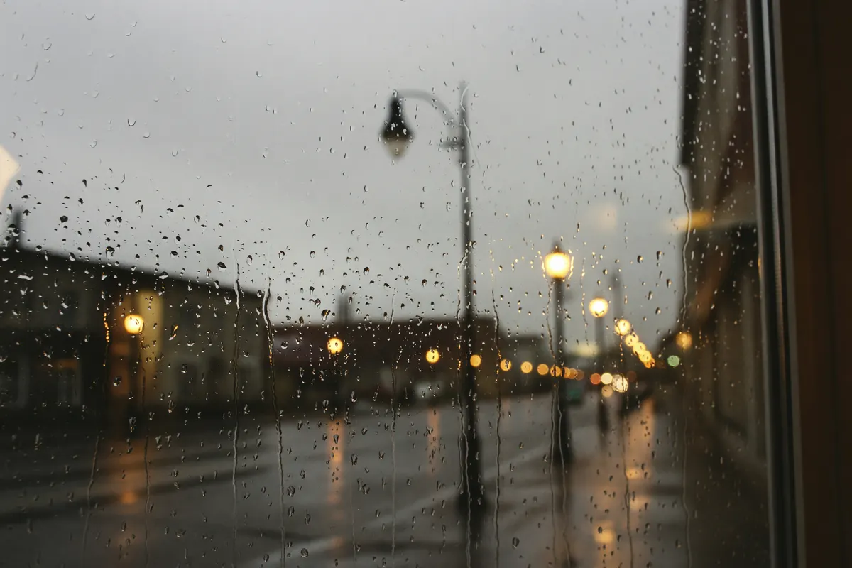 streetlights glowing outside in the rain