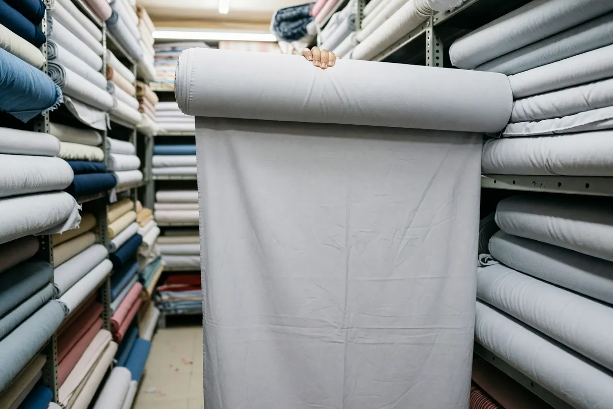 hand holding up the gray fabric bolt at the store