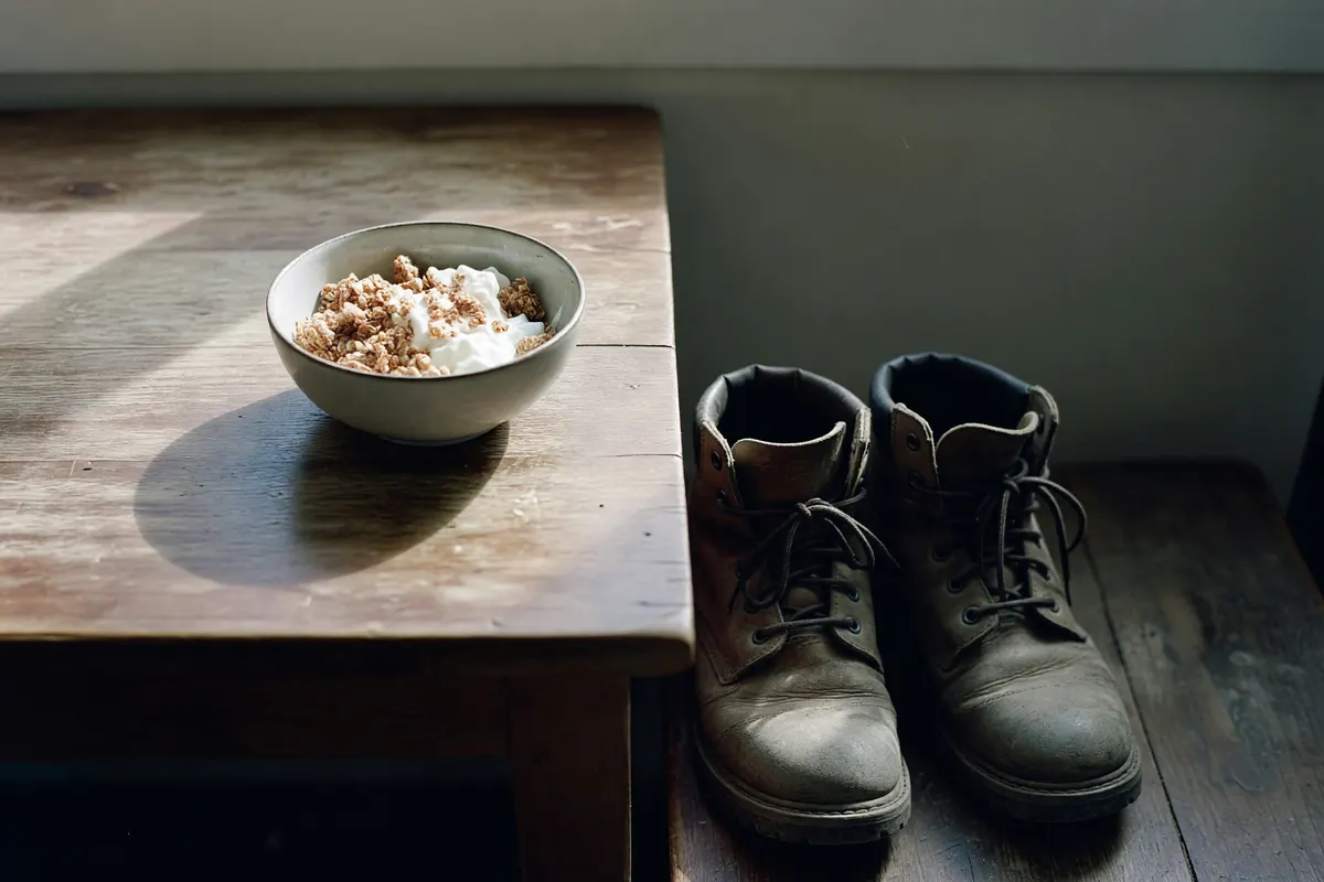 empty yogurt bowl with a spoon beside ren’s boots